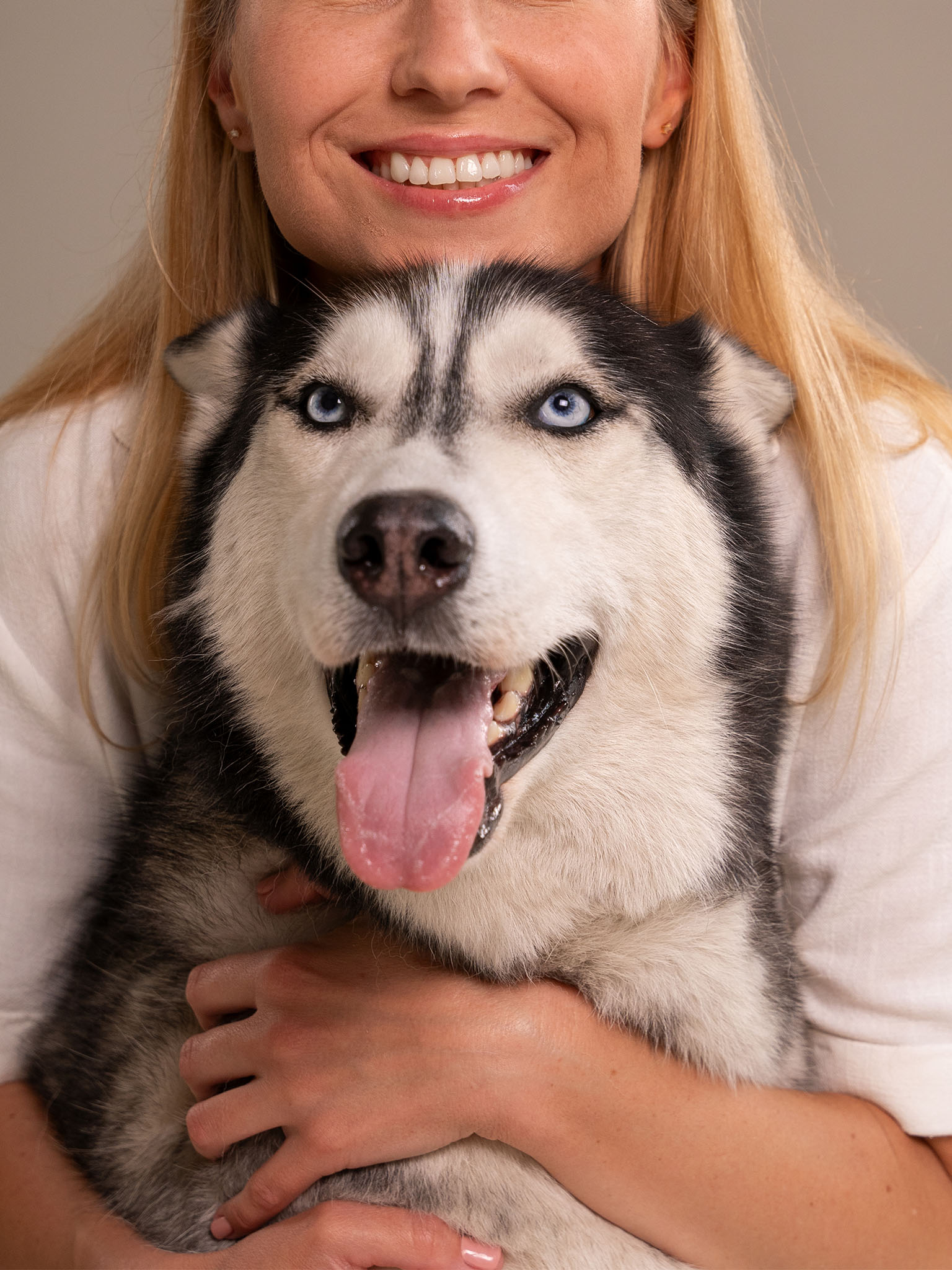 a person holding a husky dog